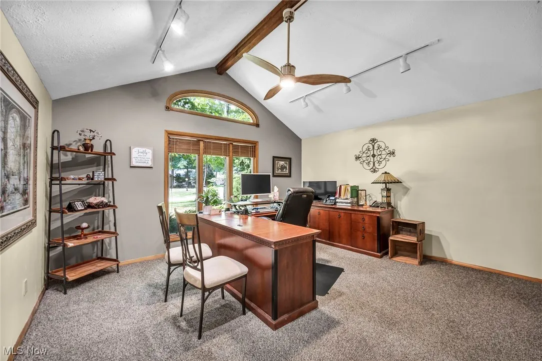 Office space featuring rail lighting, light carpet, beamed ceiling, high vaulted ceiling, and a ceiling fan