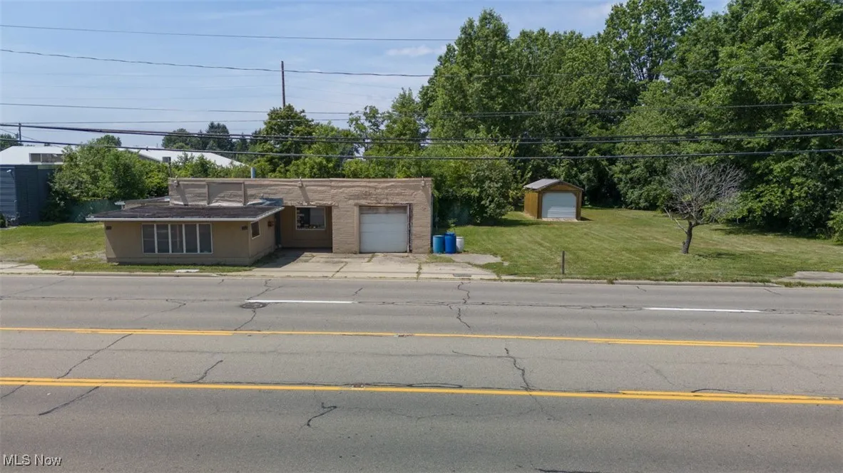 View of front of property with a front yard, driveway, and a garage