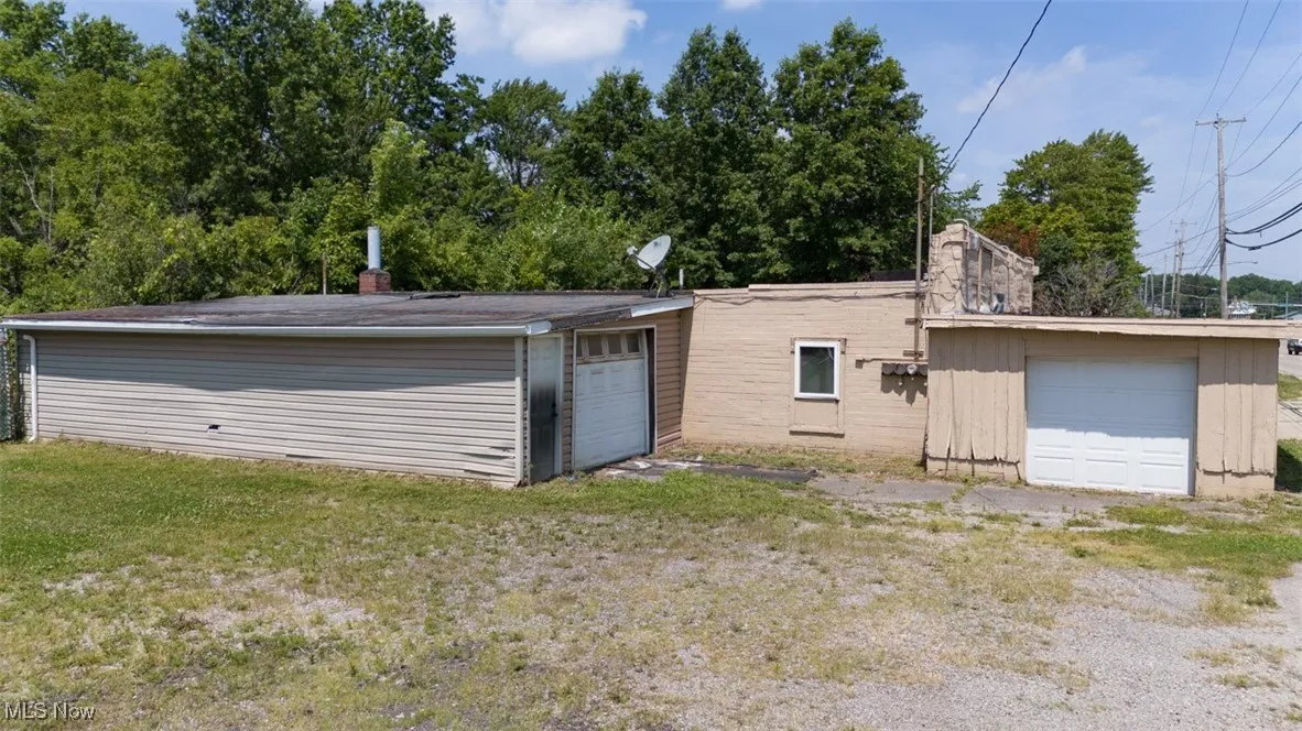 Rear view of property with a garage and a chimney