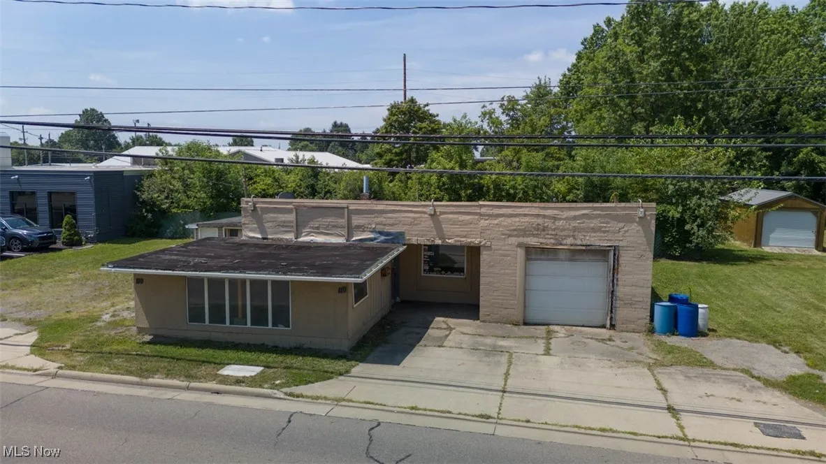 View of front of home featuring a garage, a front yard, and driveway