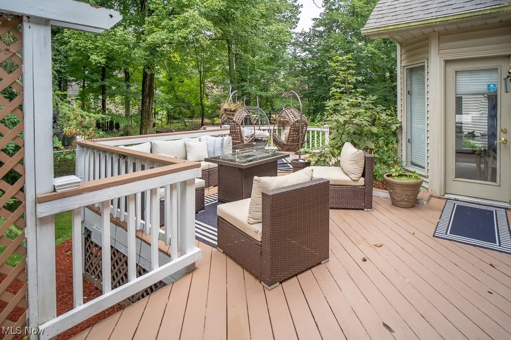 Wooden terrace featuring an outdoor living space and view of wooded area