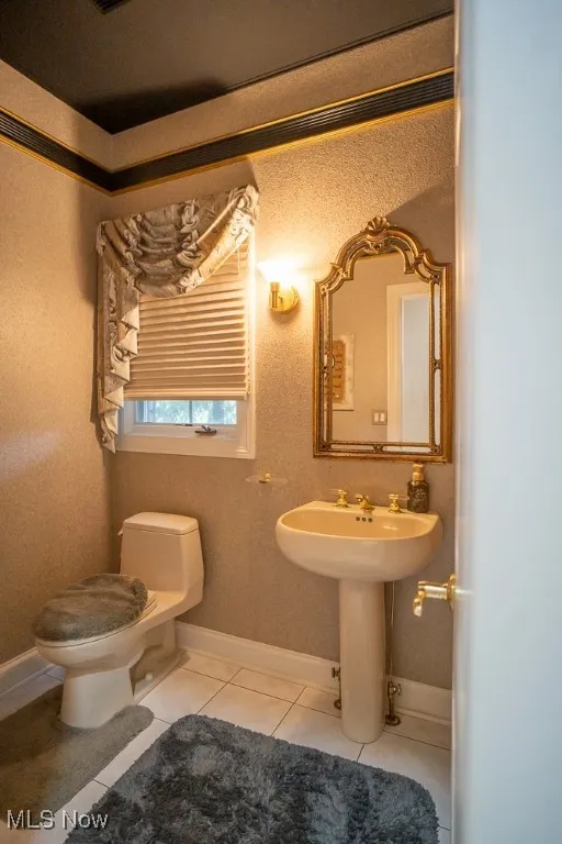Half bath featuring light tile patterned floors and a textured wall