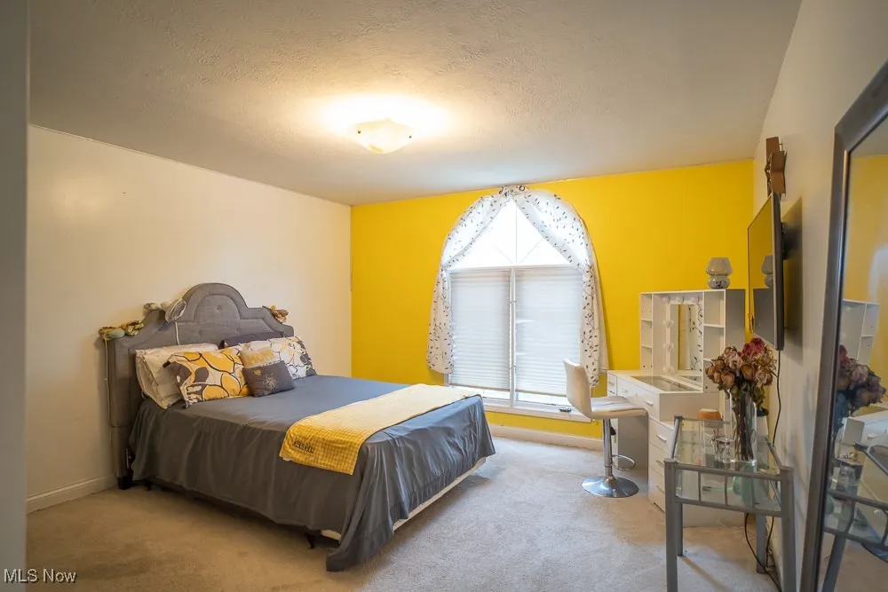 Carpeted bedroom with a textured ceiling