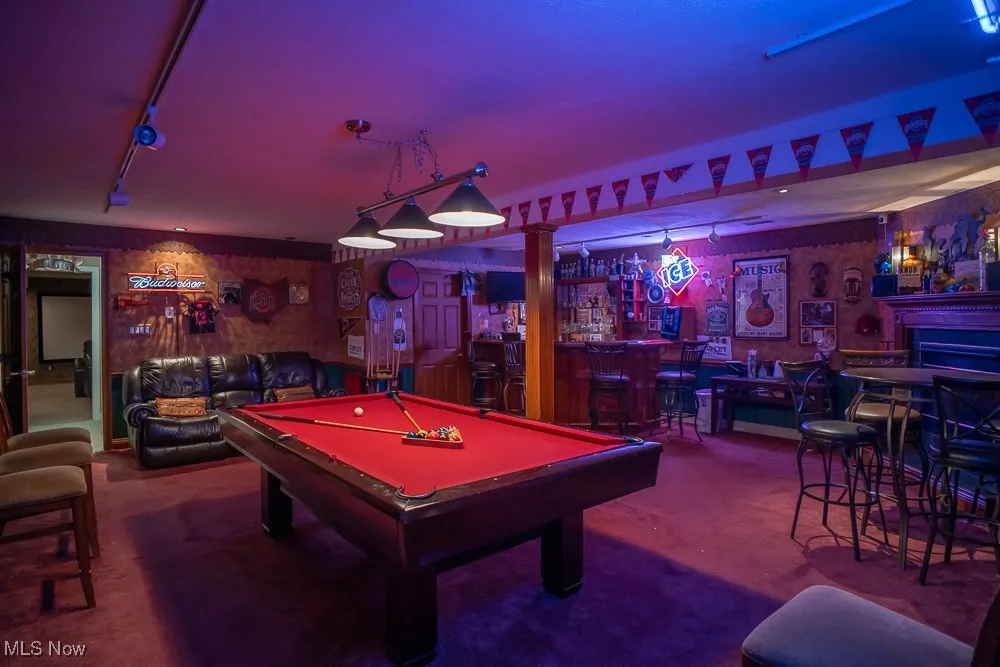 Recreation room with track lighting, pool table, dark colored carpet, and bar