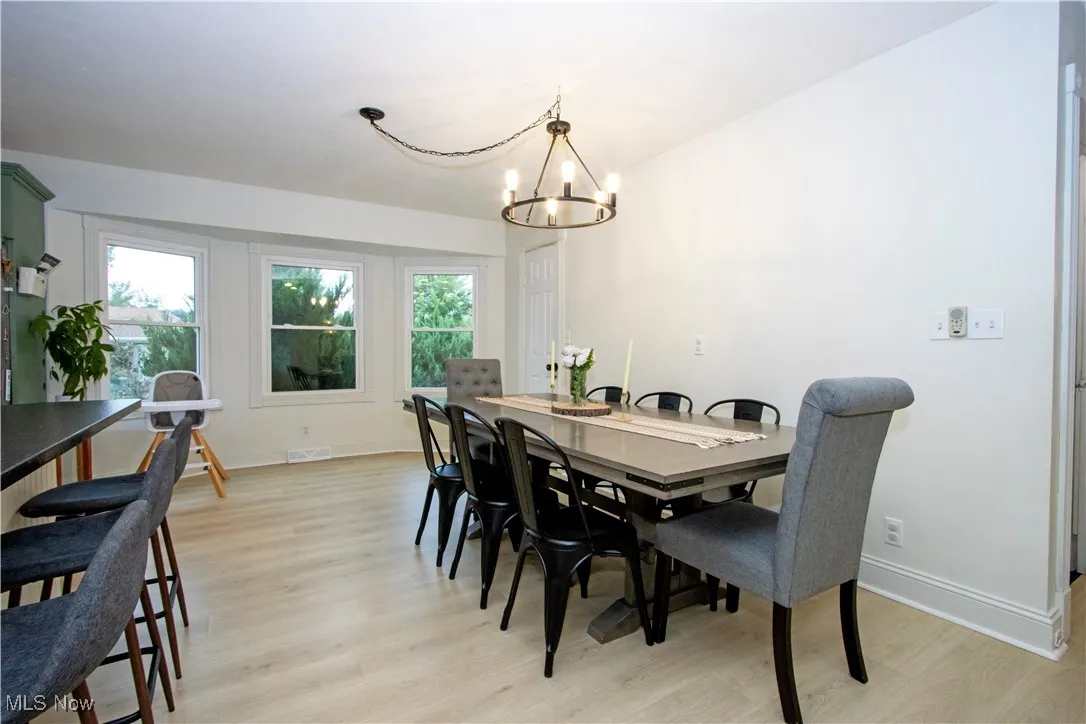 Dining area with light wood-style flooring and a chandelier