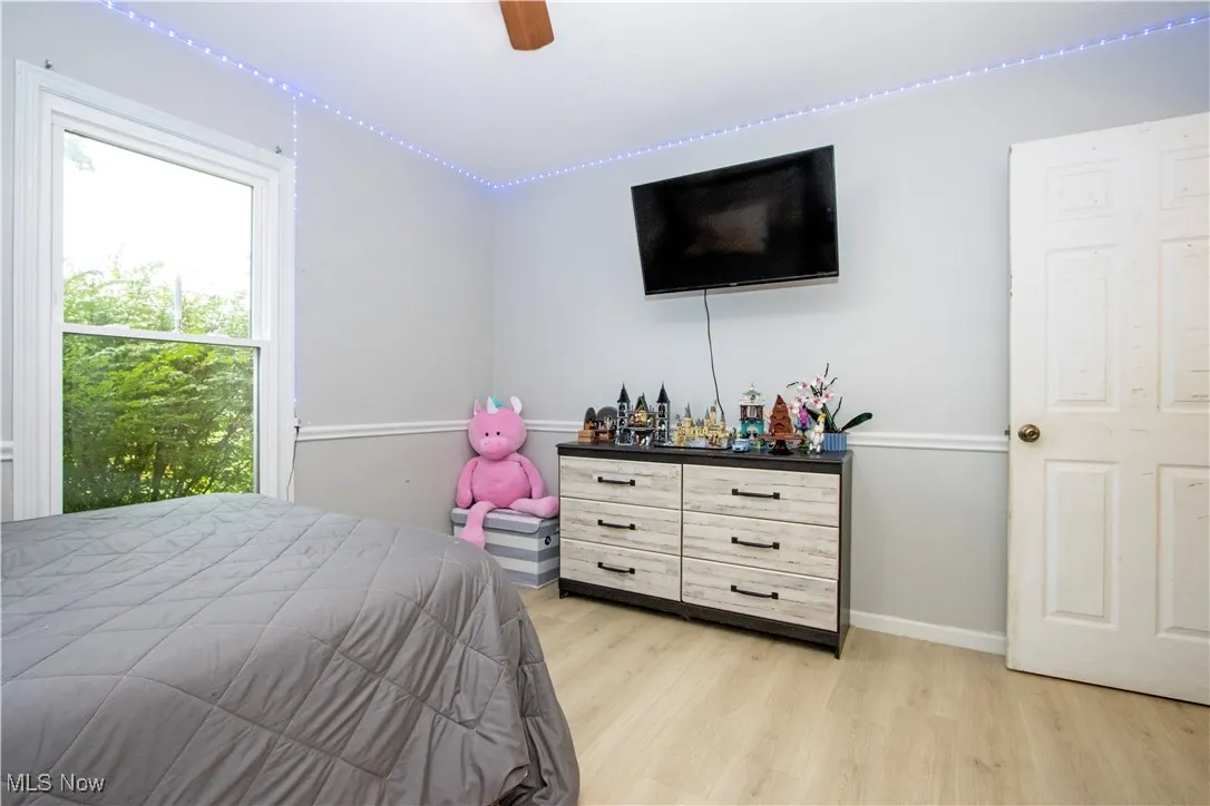 Bedroom with light wood-style flooring and a ceiling fan