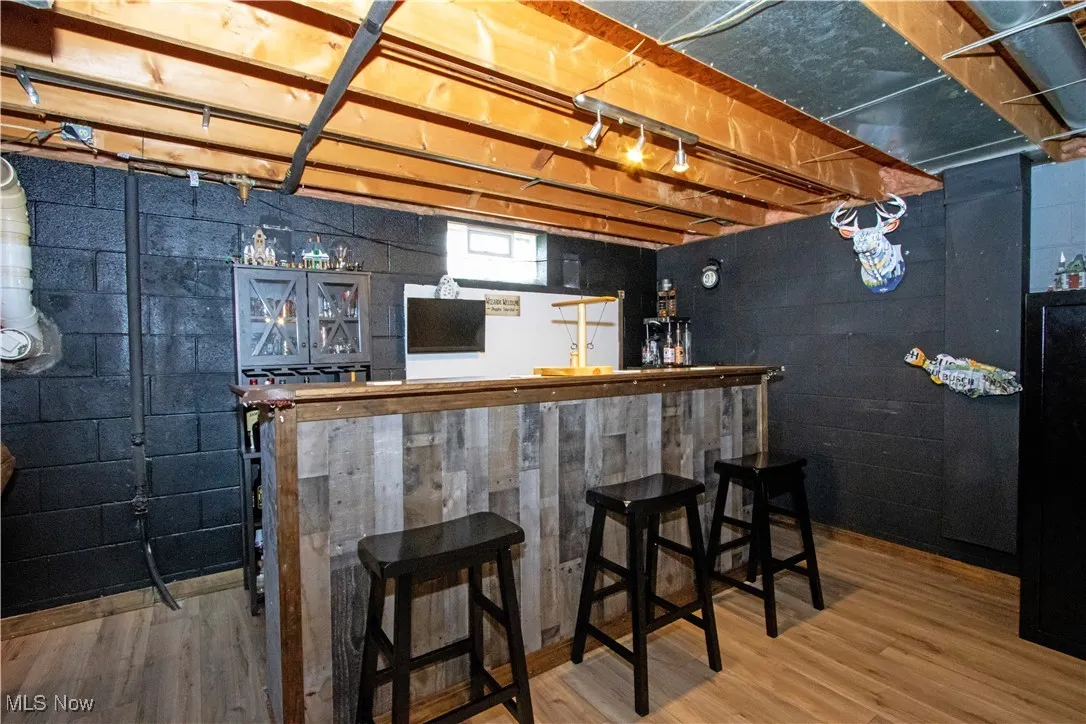 Indoor dry bar featuring wood finished floors
