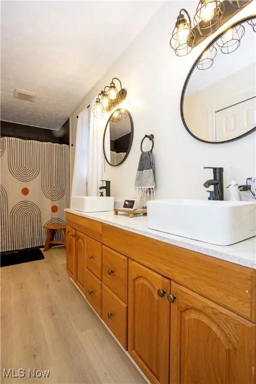 Bathroom with double vanity and light wood-style floors