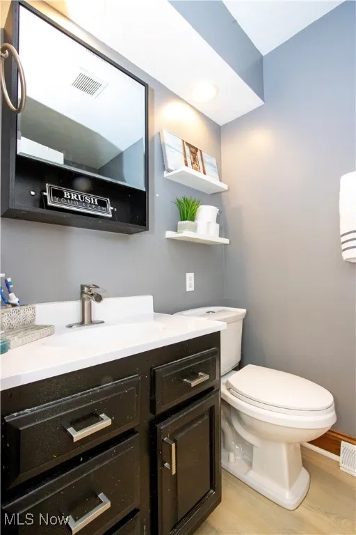 Half bath featuring vanity, light wood finished floors, and recessed lighting