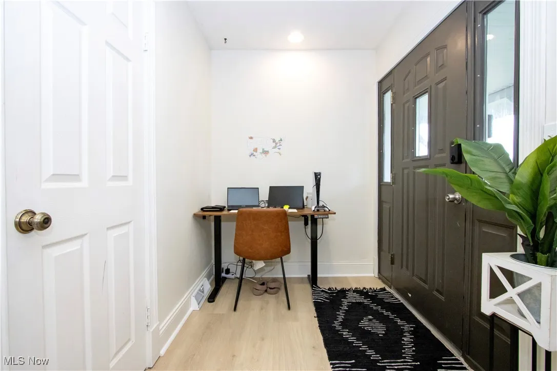 Office area featuring light wood-style floors and recessed lighting