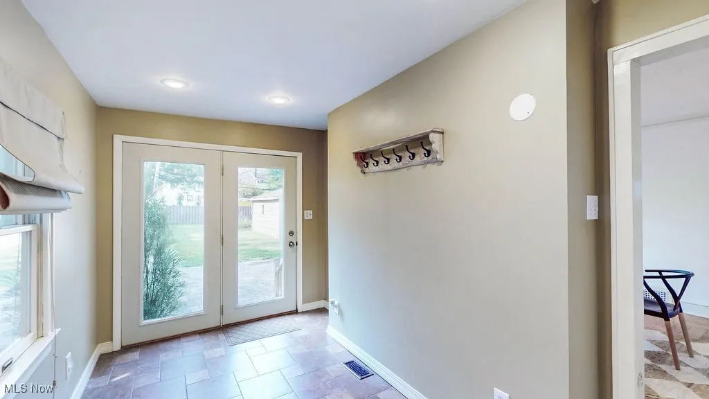 Mud room with tile floors and french doors out to patio.