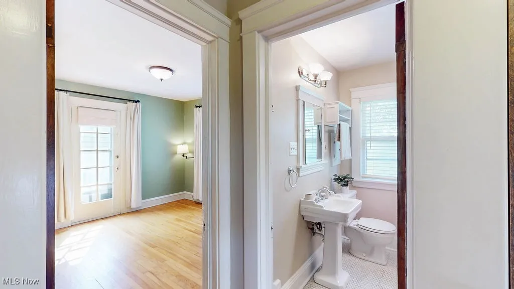 Full bath view from hallway with pedestal sink.