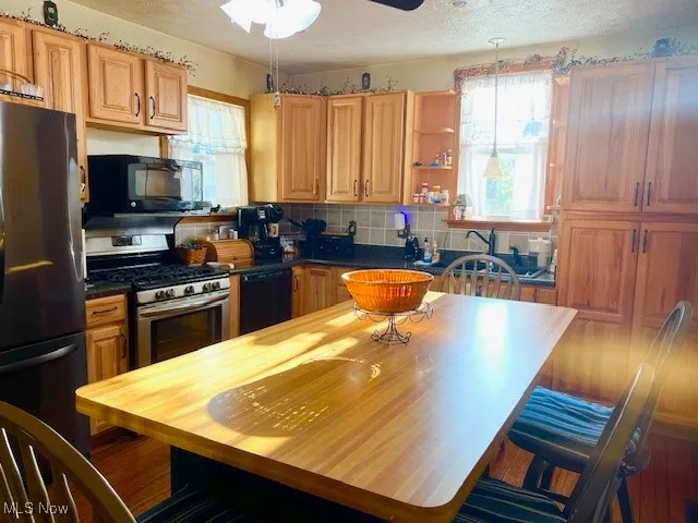 Kitchen featuring black appliances, ceiling fan, decorative backsplash, a textured ceiling, and open shelves