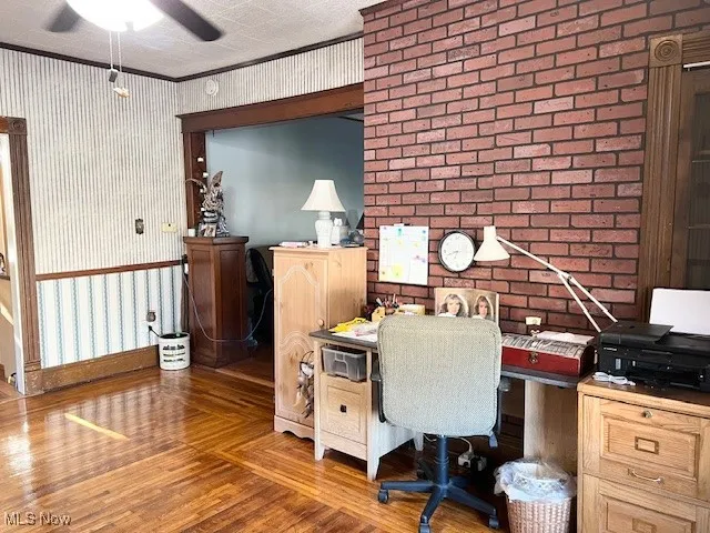 Home office with wallpapered walls, ornamental molding, a ceiling fan, and parquet floors
