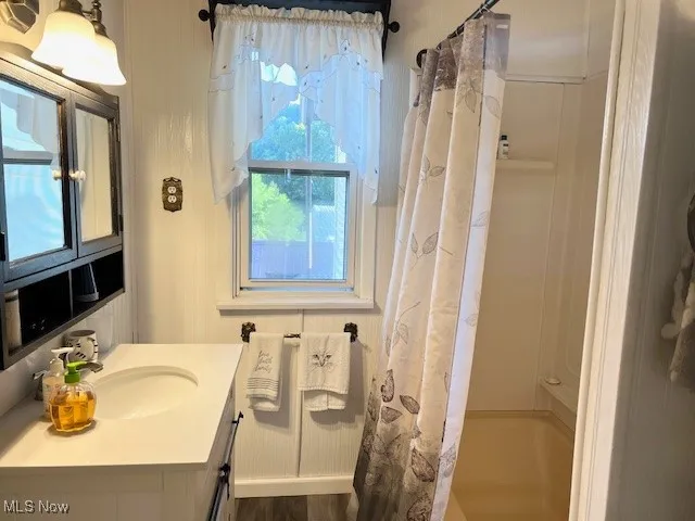 Full bath with shower / bath combo with shower curtain and vanity