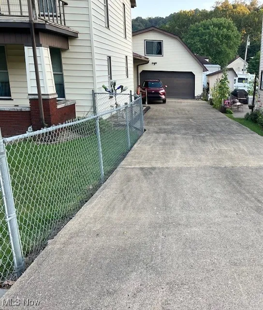 View of side of home featuring driveway and an attached garage
