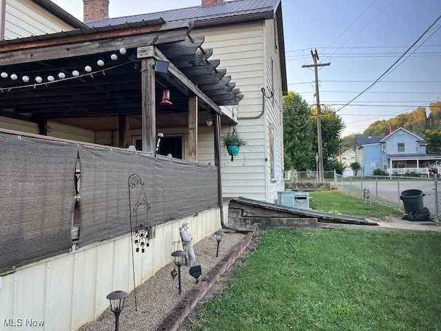 View of property exterior featuring a chimney and a metal roof