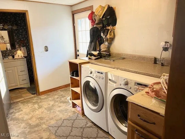 Laundry area with stone finish flooring and washer and clothes dryer