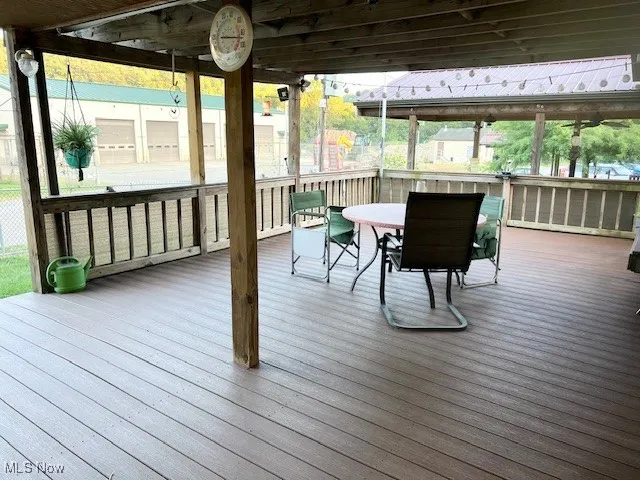 Sunroom / solarium with outdoor dining area and a wooden deck
