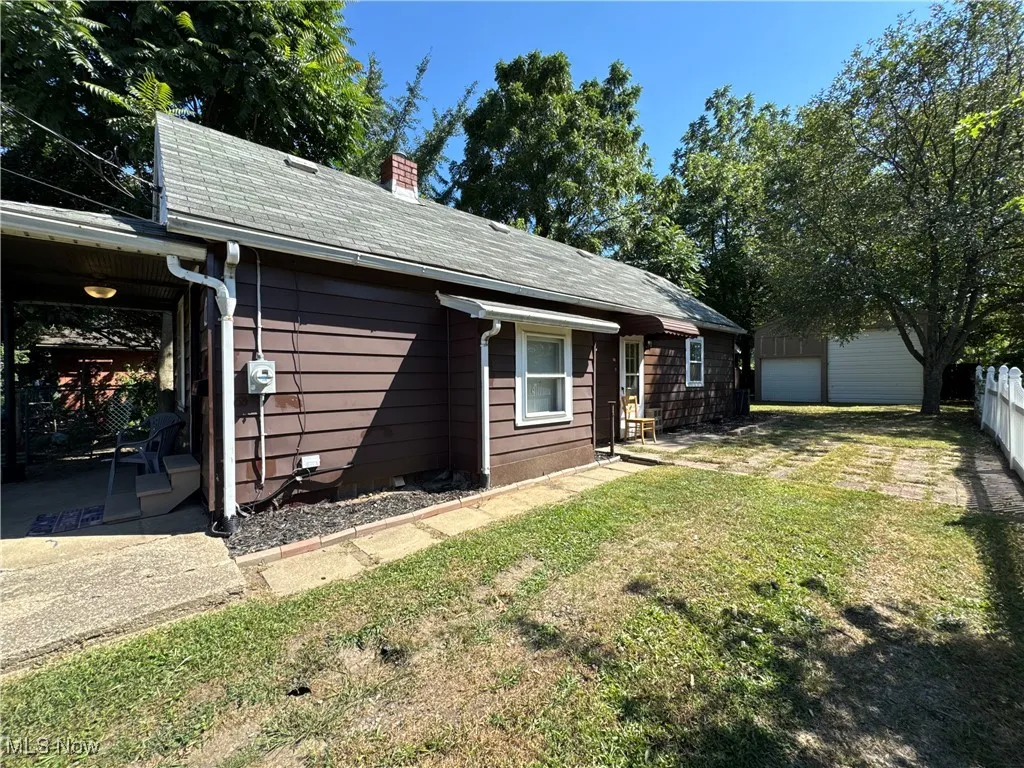 Rear view of property with a chimney and roof with shingles