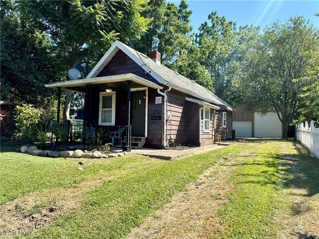View of front of house with covered porch and a chimney