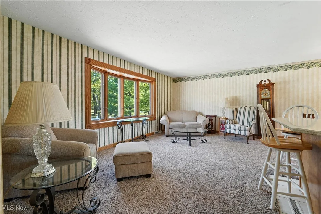 Large living room with bay window overlooking the pool and patio