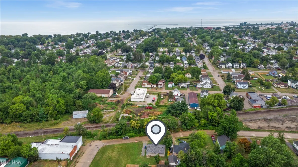 Aerial view of property and surrounding area with nearby suburban area and a large body of water