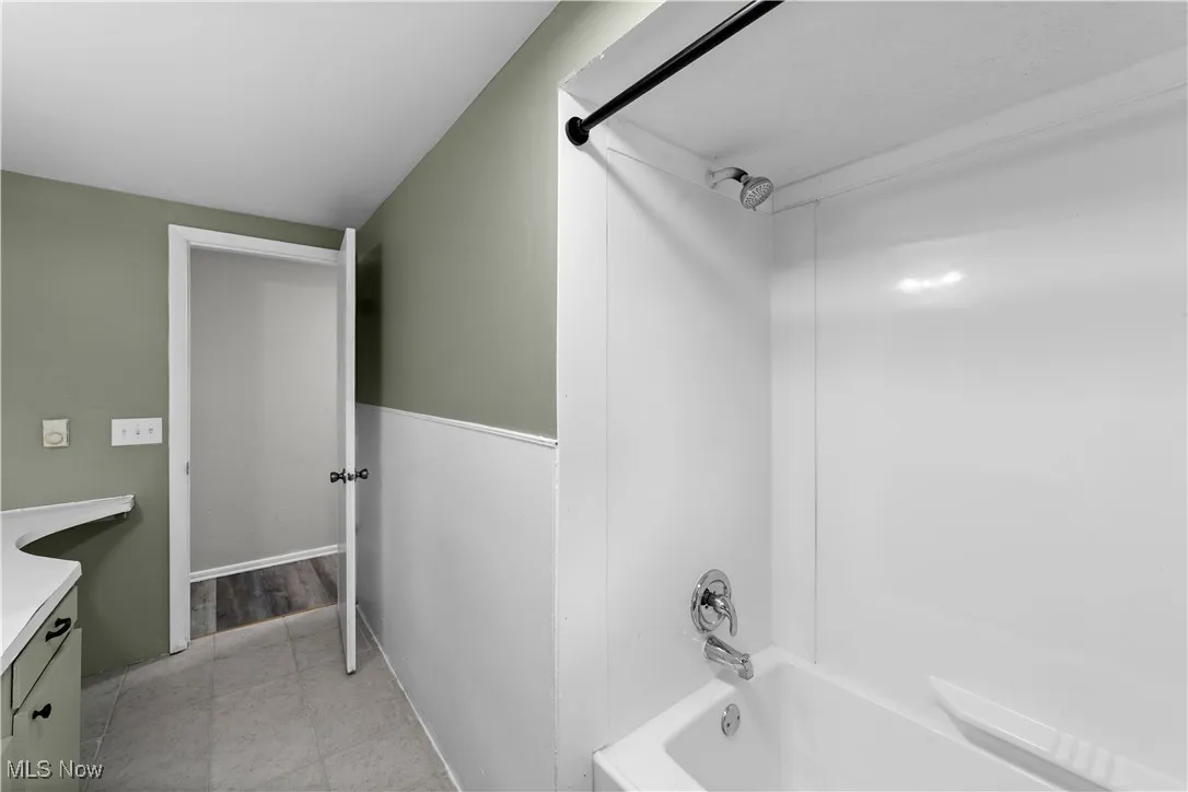 Bathroom featuring vanity, shower / washtub combination, and light tile patterned floors