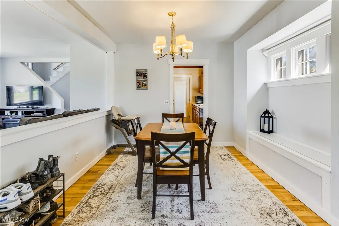 Dining space with light wood-style floors, a chandelier, and stairs