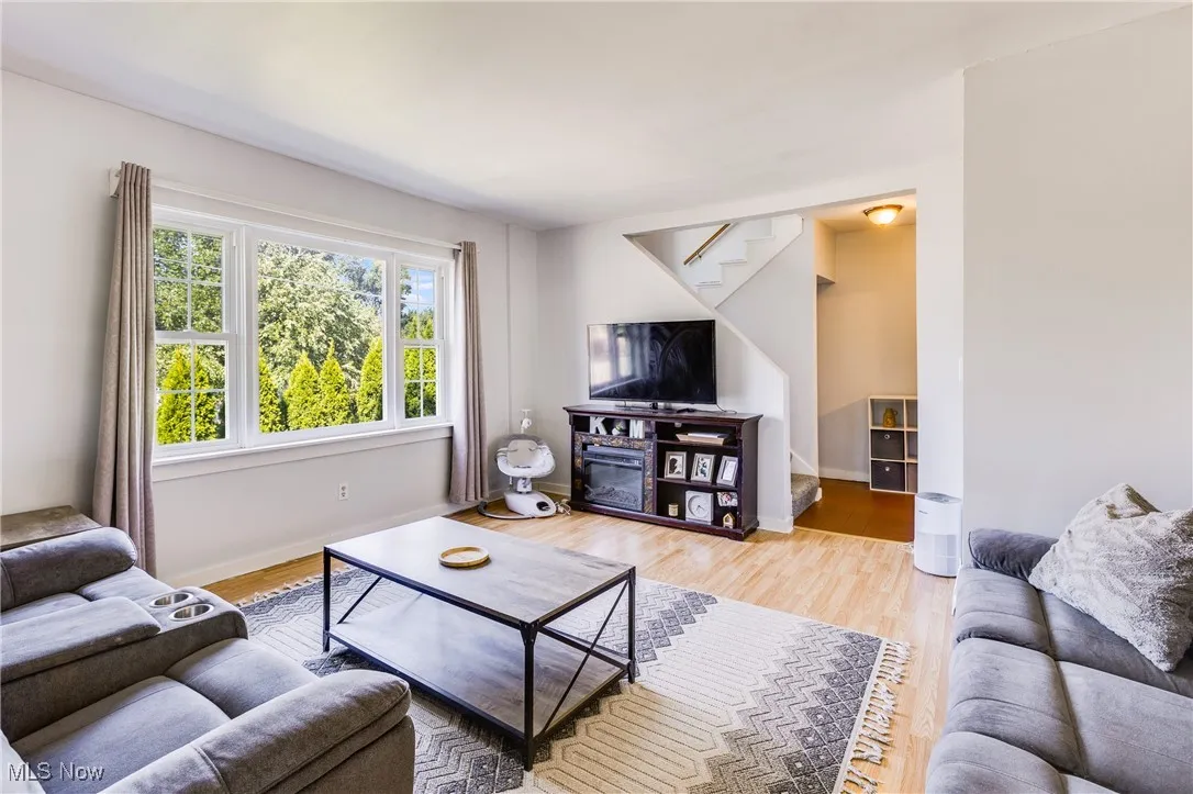 Living room with light wood-style floors and stairs