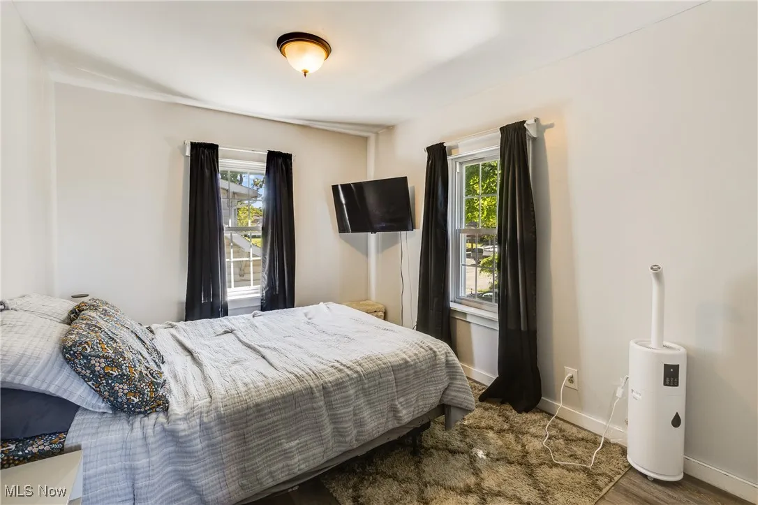 Bedroom with baseboards and dark wood-type flooring