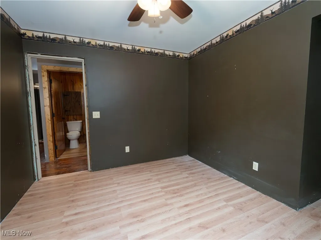 Spare room with wood finished floors and a ceiling fan