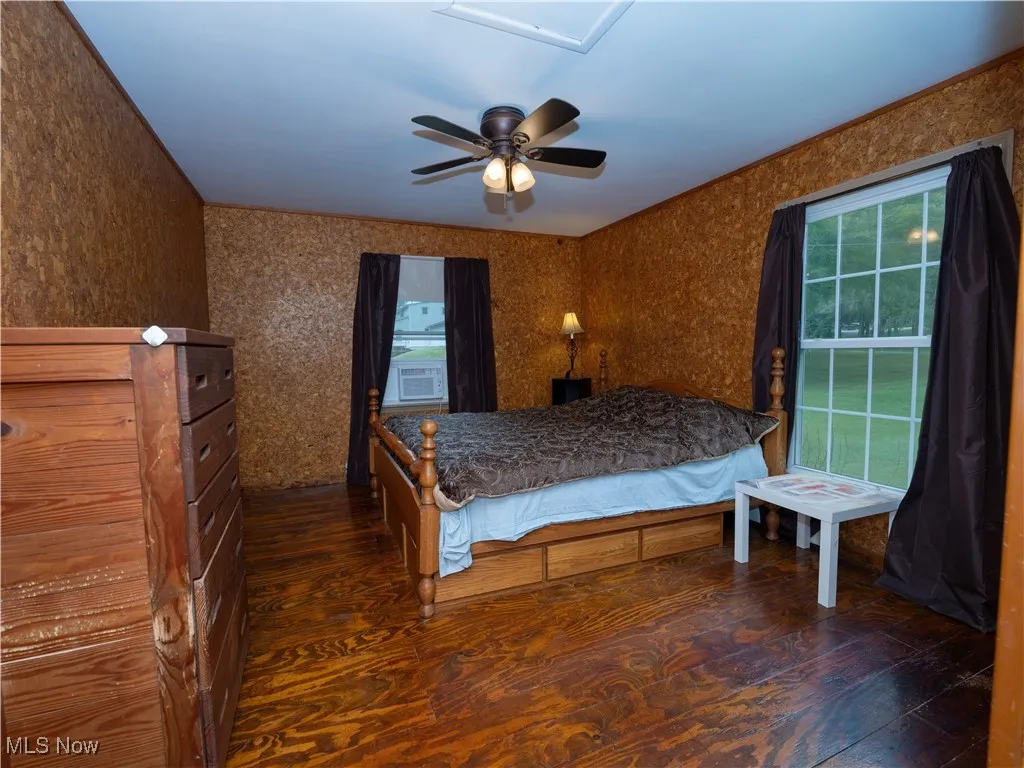Bedroom with dark wood-style floors and ceiling fan