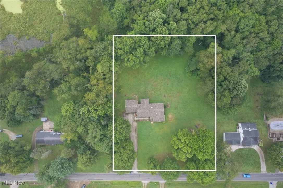 Aerial view of property and surrounding area featuring property boundaries highlighted