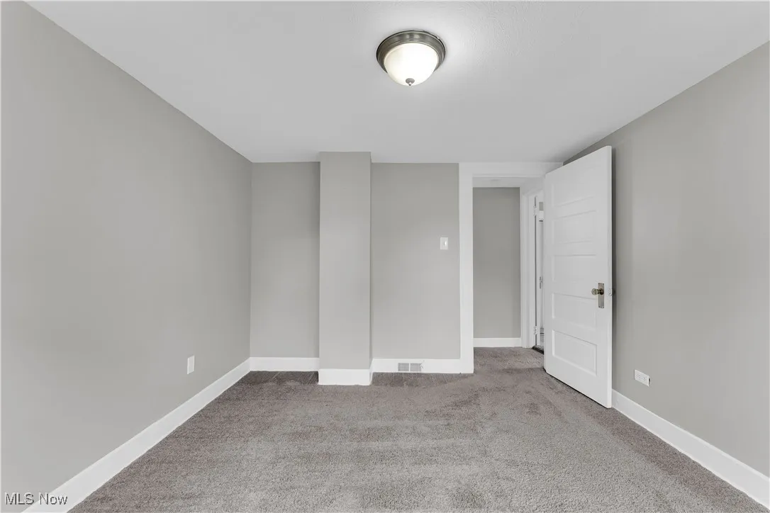 Spare room with light carpet and baseboards