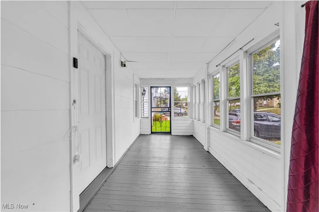 Unfurnished sunroom with a paneled ceiling and wood-type flooring