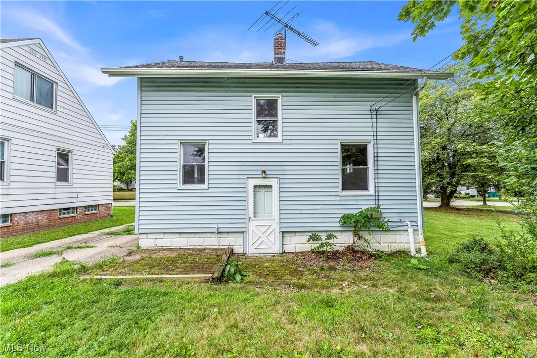 Back of house with a yard and a chimney
