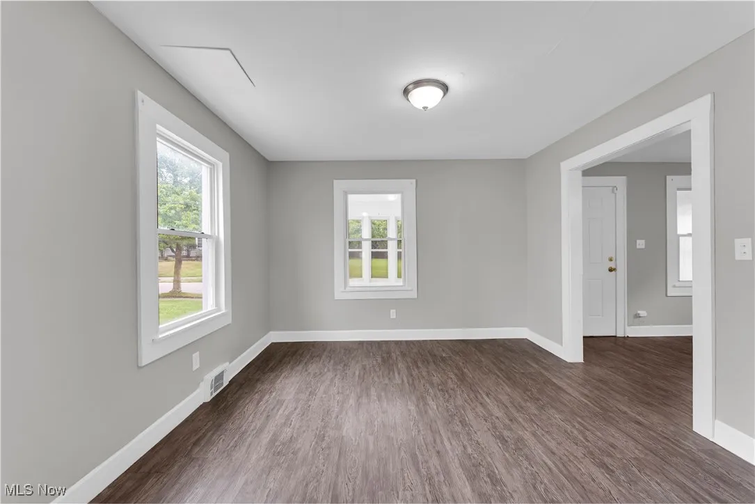 Spare room with dark wood-type flooring