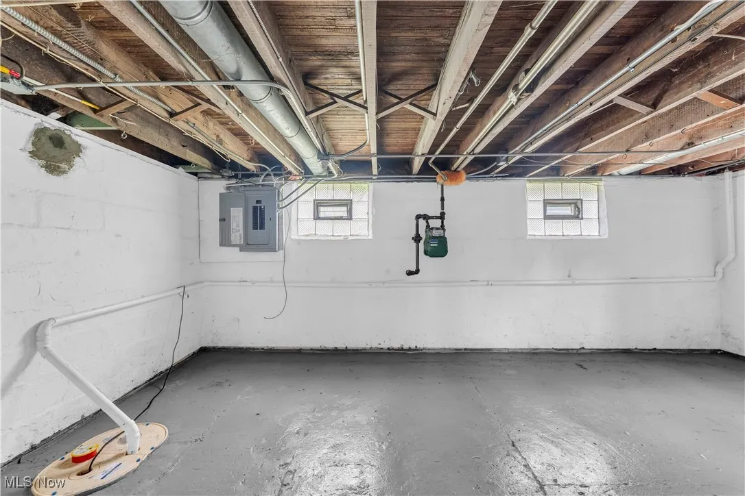Basement featuring electric panel and plenty of natural light