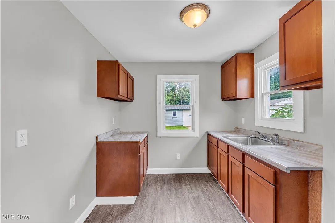 Kitchen featuring brown cabinetry, light countertops, plenty of natural light, and light wood-style floors