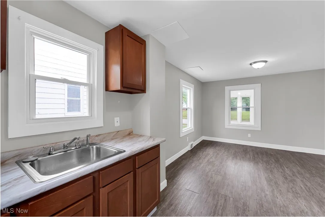 Kitchen with brown cabinets, light countertops, and dark wood-style floors
