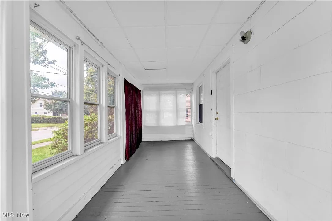 Hall featuring a paneled ceiling and hardwood / wood-style flooring