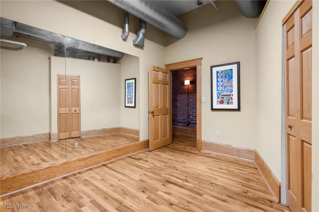 Unfurnished bedroom featuring wood finished floors, ceiling fan, and a towering ceiling