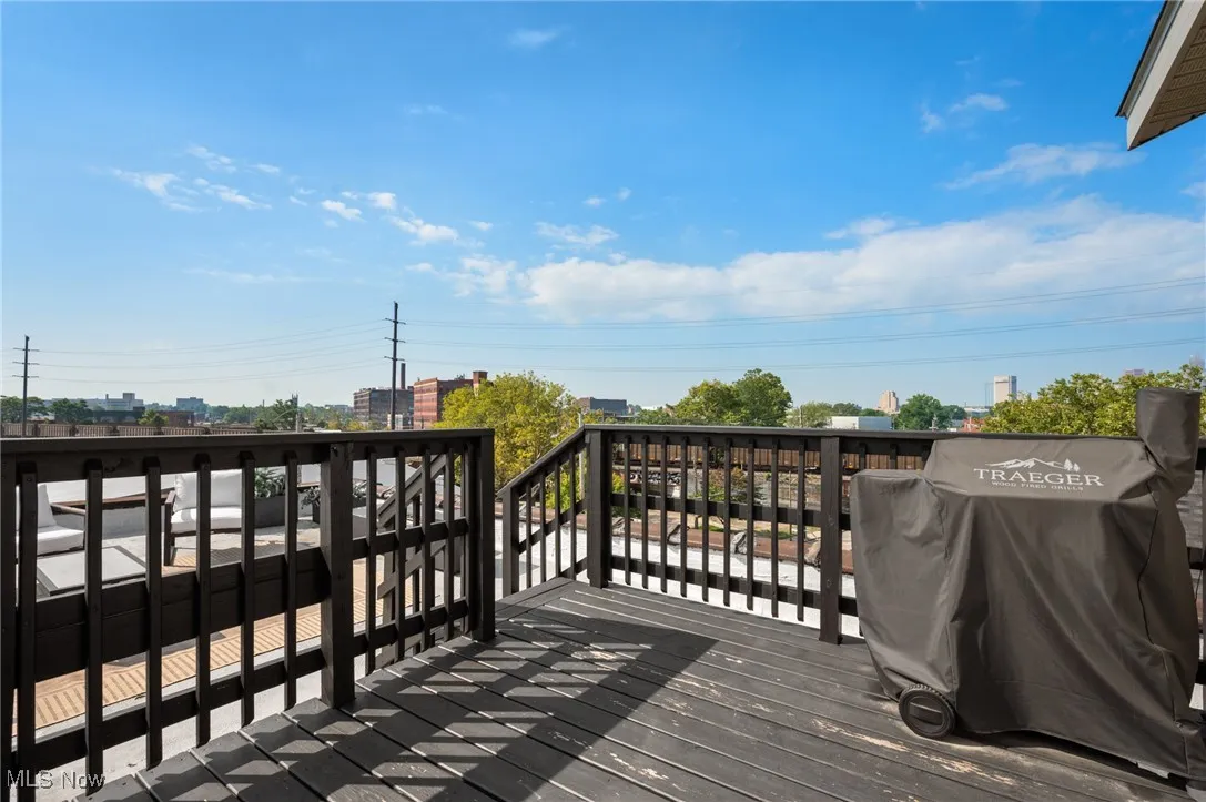 Wooden terrace featuring a grill