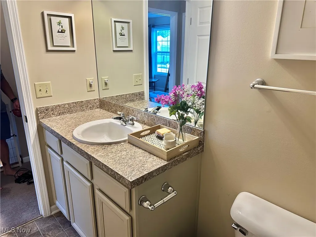 Bathroom featuring vanity and dark tile patterned floors