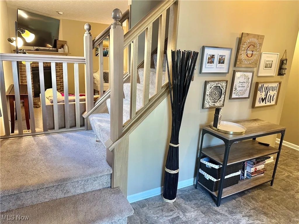 Stairway with baseboards and a textured ceiling