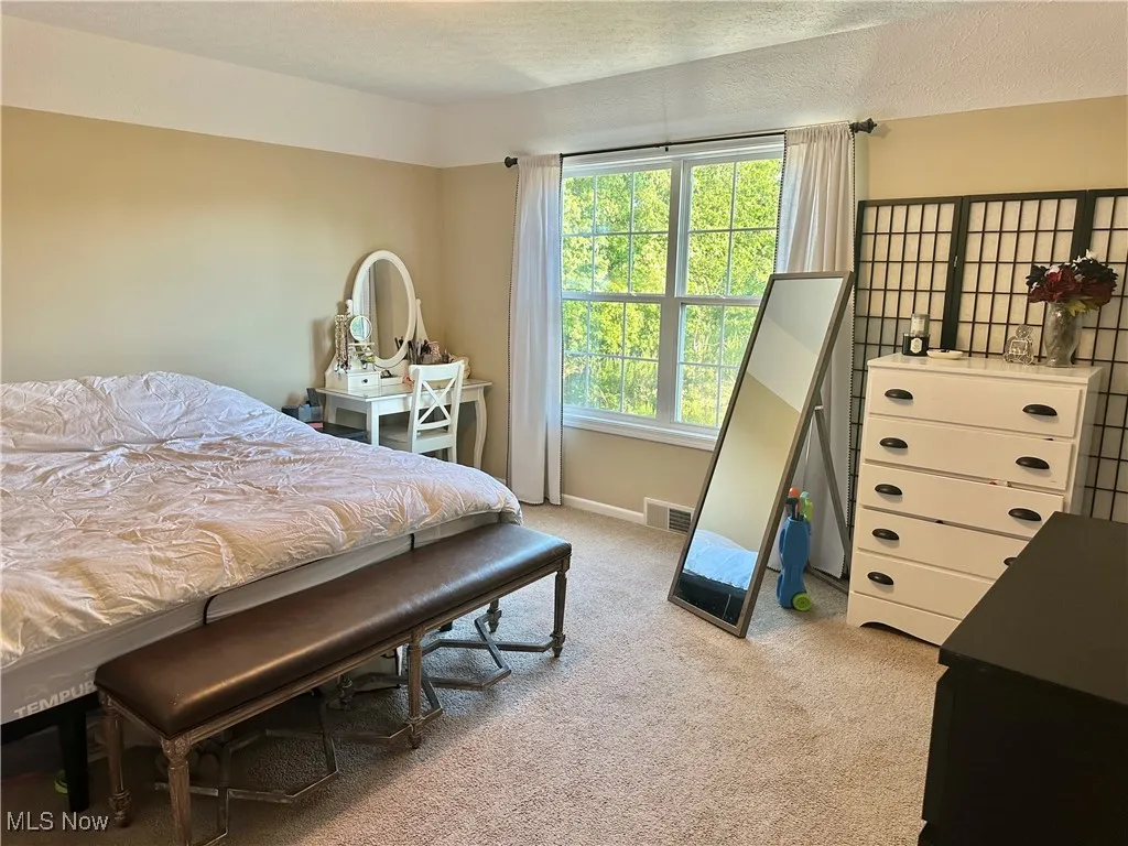 Bedroom featuring light carpet and a textured ceiling