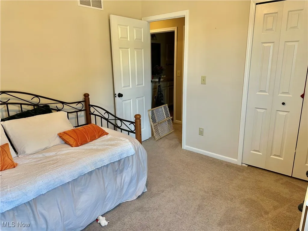 Bedroom featuring light colored carpet and a closet