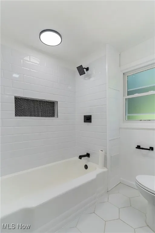 Full bathroom with shower / washtub combination and light tile patterned floors