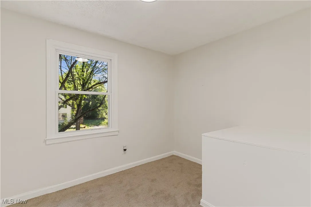 Empty room with baseboards and light carpet